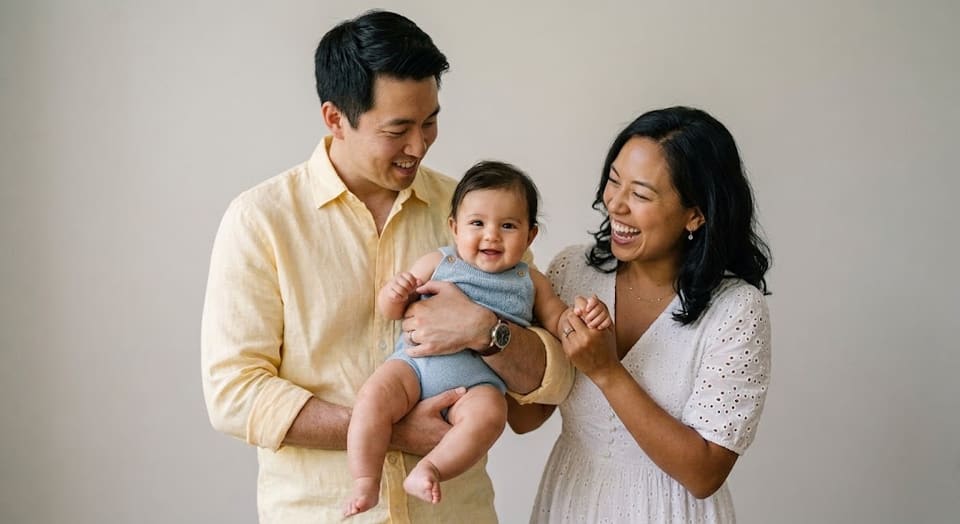 Father and mother lifting and smiling at their baby